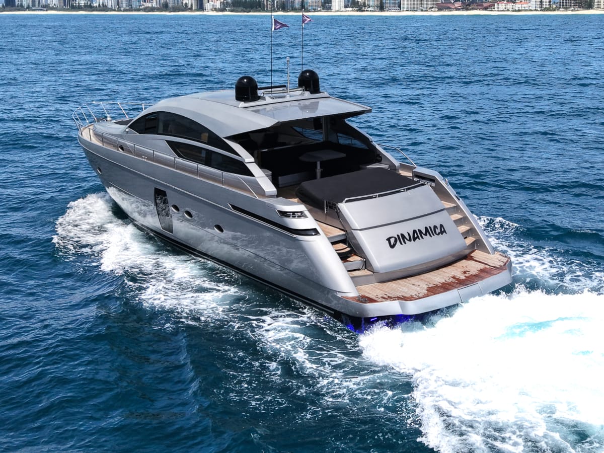 Silver performance motor yacht underway with professional vessel support